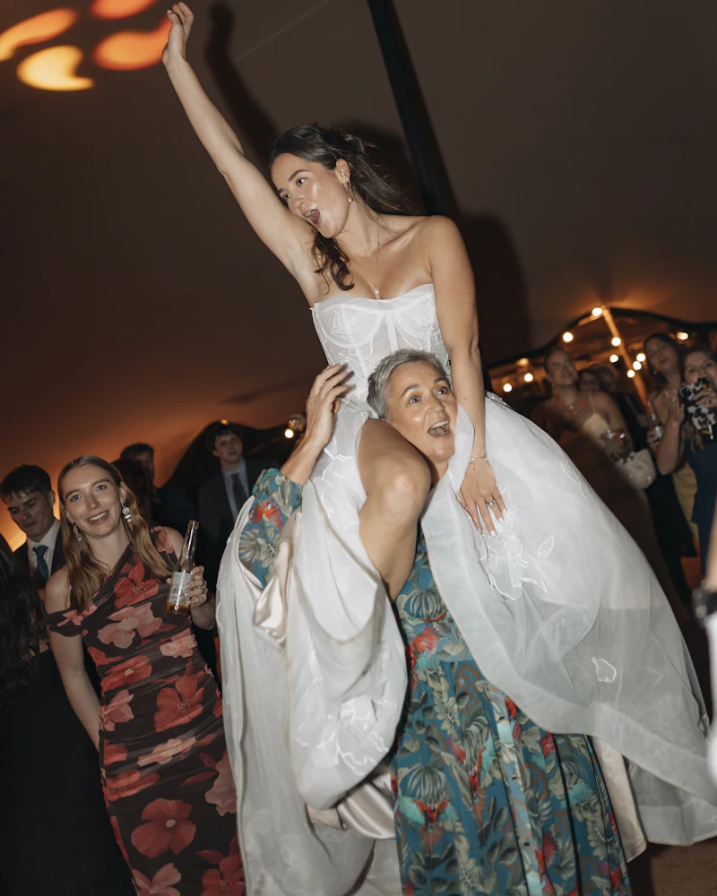 Bride carried on the guests’ shoulders mid-party