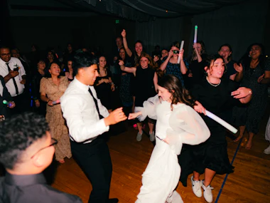 Newlyweds dancing surrounded by guests
