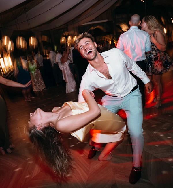 Couple dancing energetically at an outdoor party