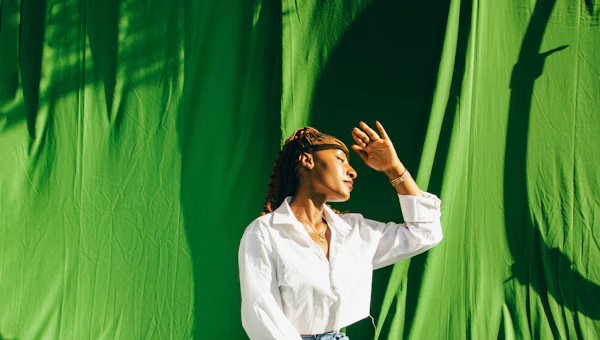Woman posing in front of a green backdrop