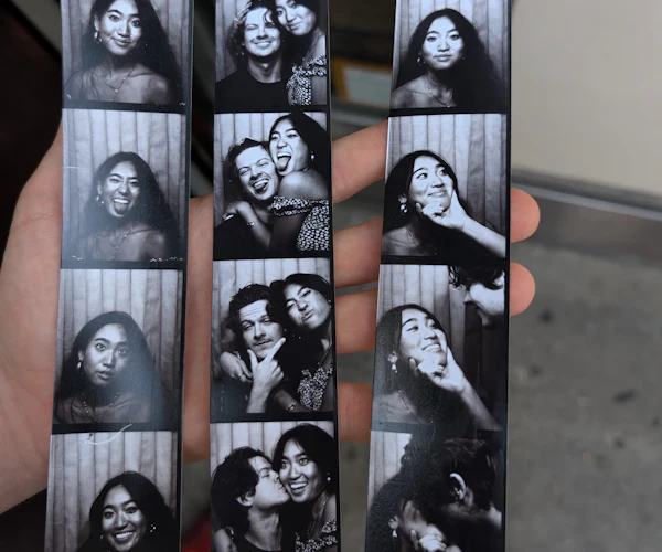 Mà que sosté tres tires de fotomaton en blanc i negre