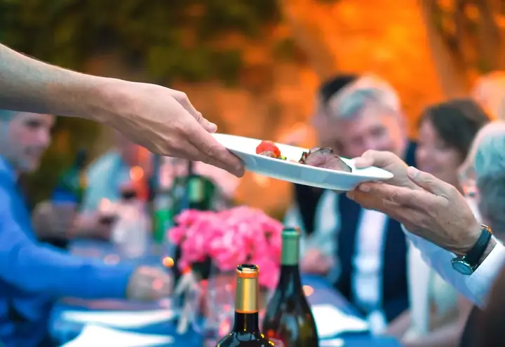 A plate being served at an outdoor dinner