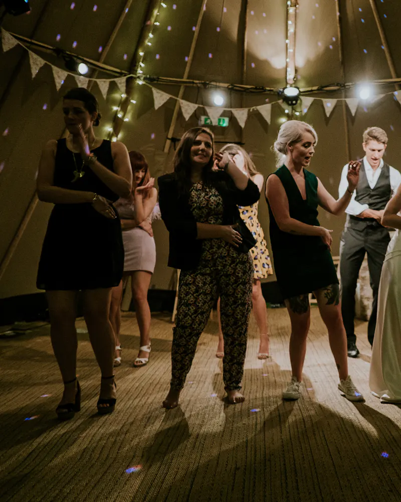 Guests dancing under a marquee hung with bunting