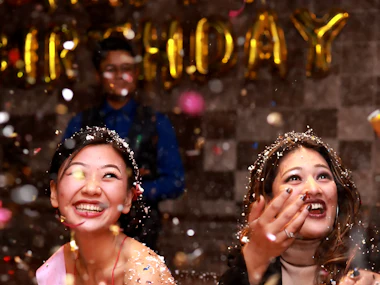 Two friends celebrating in a shower of glitter